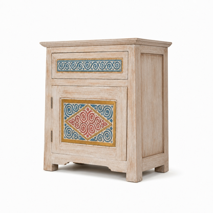 A rustic light beige wooden nightstand with a distressed finish, featuring hand-painted geometric and scroll patterns in blue, red, and gold on the front panels.